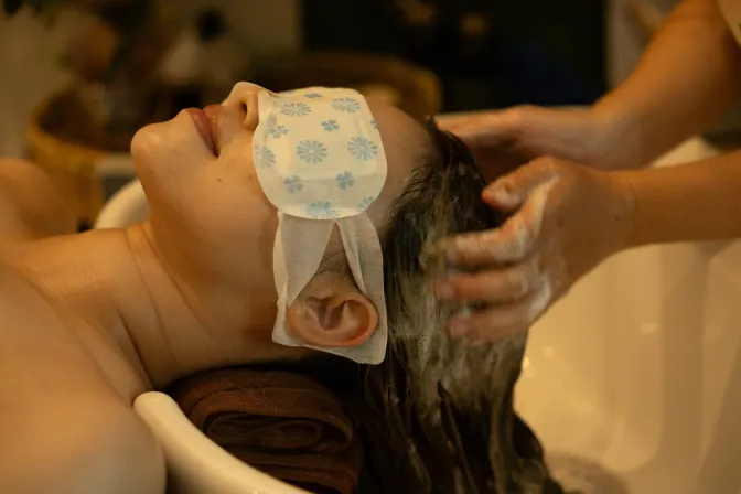 Vrouw ligt ontspannen, terwijl ze een Harmony Tide Ritual japanese head spa massage krijgt